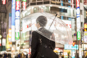 A businessman with an umbrella in the brightly lit streets in the evening A businessman with an umbrella in the brightly lit streets in the evening