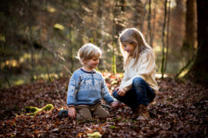 Junge und Mädchen spielen im Herbstwald Junge und Mädchen spielen im Herbstwald