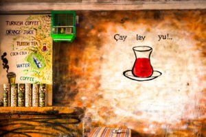 Teehaus, türkisches Teeglas an die Wand gemalt, Wellensittich im Käfig, warme Farben Teehaus, türkisches Teeglas an die Wand gemalt, Wellensittich im Käfig, warme Farben