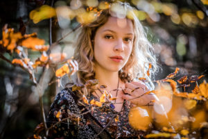 junge Frau mit blonden Haaren im Wald, ernster und nachdenklicher Blick junge Frau mit blonden Haaren im Wald, ernster und nachdenklicher Blick
