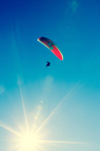 Paraglider, blue sky and sunbeams Paraglider, blue sky and sunbeams