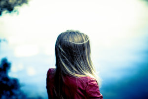 Young girl, teenager, long blond hair, facing lake Young girl, teenager, long blond hair, facing lake