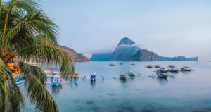 Panoramic scene of trip tourist boats in El Nido at evening sunset light. Palawan, Philippines. Cadlao island in background. Panoramic scene of trip tourist boats in El Nido at evening sunset light. Palawan, Philippines. Cadlao island in background.