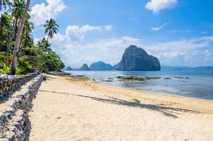 Sunny Marimegmeg Beach in Low Tide in El Nido, Bar under Palms in Front, Palawan, Philippines