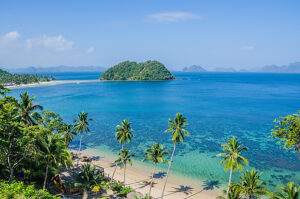 Tropical Beach with Palm trees. Many Islands in ocean in Background, El Nido, Palawan, Philippines.