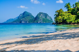 Sandy Beach with Palm Shadows, Huge Rocks in Background, El Nido, Palawan, Philippines.