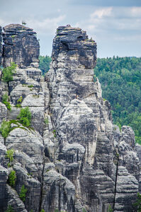 Alpinists on the top of relief camstone stones in Saxony national park, Bastei, Germany.