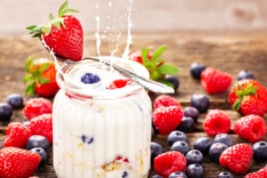 Yogurt in glass with fresh berries on wood Yogurt in glass with fresh berries on wood