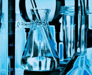 Glass vials and beakers used in medical scientific research lab.