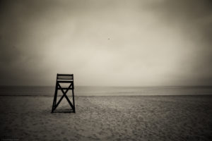 Lifeguard stand on deserted beach with distand seagulls