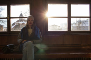 Frau vor Fenstern gegen die Sonne fotografiert Frau vor Fenstern gegen die Sonne fotografiert