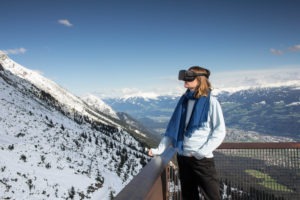 Person mit Virtual-Reality-Brille vor Bergkulisse