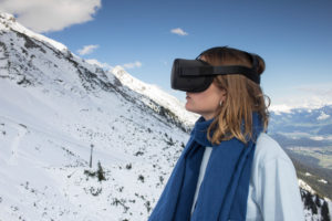 Person mit Virtual-Reality-Brille vor Bergkulisse