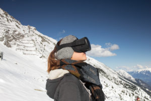 Person mit Virtual-Reality-Brille vor Bergkulisse