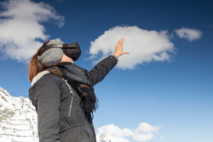 Person mit Virtual-Reality-Brille vor Bergkulisse