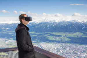 Person mit Virtual-Reality-Brille vor Bergkulisse