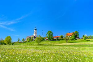 Germany, Bavaria, Tölzer Land, Isarwinkel, Gaißach, Spring meadow with St. Michael's Church