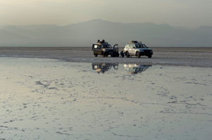 Two all-wheel drive vehicles stand in the pale evening light in front of a brine on the edge of the Assale Salt Lake, Hamedala, Danakil Valley, Afar Region, Ethiopia Two all-wheel drive vehicles stand in the pale evening light in front of a brine on the edge of the Assale Salt Lake, Hamedala, Danakil Valley, Afar Region, Ethiopia