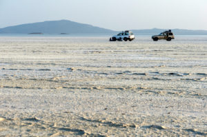 Off-road vehicles looking lost on the salt crust of the Assale Salt Lake over 100 m below sea level, Danakil Depression, Afar Triangle, Ethiopia Off-road vehicles looking lost on the salt crust of the Assale Salt Lake over 100 m below sea level, Danakil Depression, Afar Triangle, Ethiopia