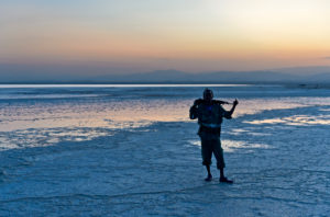 Security guard with Kalashnikov at Assale salt lake at sunset, Hamadela, Danakil Depression Afar triangle, Ethiopia Security guard with Kalashnikov at Assale salt lake at sunset, Hamadela, Danakil Depression Afar triangle, Ethiopia