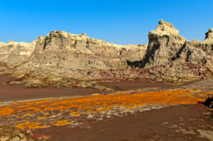 Eroded deposits of potassium and magnesium salts and rust-red clay in the salt canyon of the Dallol volcano, Hamadela, Danakil depression, Afar triangle, Ethiopia Eroded deposits of potassium and magnesium salts and rust-red clay in the salt canyon of the Dallol volcano, Hamadela, Danakil depression, Afar triangle, Ethiopia
