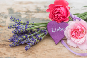 bouquet of lavender and small moss roses on old wooden board with heart and writing 'Liebe' bouquet of lavender and small moss roses on old wooden board with heart and writing 'Liebe'