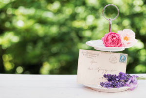 floral still life with lavender, roses and old letter in the green back light on old wooden board floral still life with lavender, roses and old letter in the green back light on old wooden board