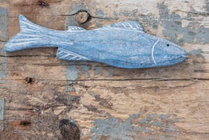 Maritime still life, blue wooden fish on old weather-beaten wooden board Maritime still life, blue wooden fish on old weather-beaten wooden board