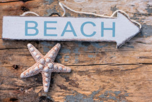 Maritime still life, sign "Beach" and starfish on old wooden board Maritime still life, sign "Beach" and starfish on old wooden board