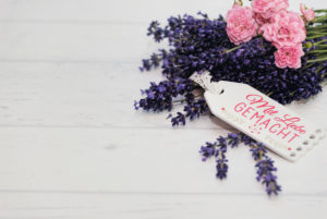 floral still life, bunch of lavender and pink roses with small sign "mit Liebe gemacht" on old wooden board floral still life, bunch of lavender and pink roses with small sign "mit Liebe gemacht" on old wooden board