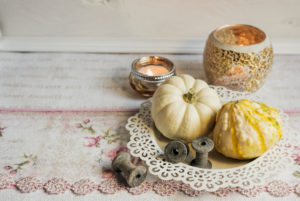 Autumnal still life with pumpkins in a white bowl, tea lights in background, Autumnal still life with pumpkins in a white bowl, tea lights in background,