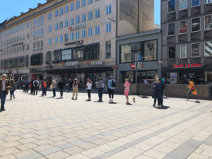 Menschen shoppen während Corona mit Sicherheitsabstand, Menschenschlange Menschen shoppen während Corona mit Sicherheitsabstand, Menschenschlange