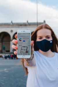 Red-haired woman with Corona warning app on iphone in Munich on Odeonsplatz Red-haired woman with Corona warning app on iphone in Munich on Odeonsplatz