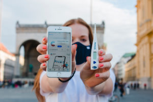 Red-haired woman with Corona warning app on iphone in Munich on Odeonsplatz Red-haired woman with Corona warning app on iphone in Munich on Odeonsplatz