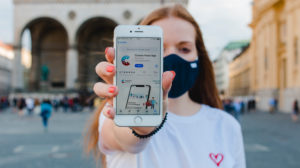 Red-haired woman with Corona warning app on iphone in Munich on Odeonsplatz Red-haired woman with Corona warning app on iphone in Munich on Odeonsplatz