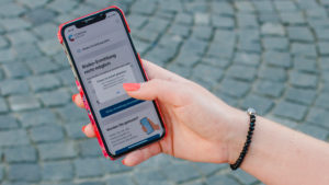 Red-haired woman with Corona warning app on Odeonsplatz in Munich / Instructions for Corona warning app Red-haired woman with Corona warning app on Odeonsplatz in Munich / Instructions for Corona warning app