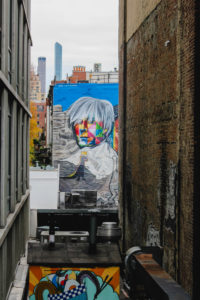Sightseeing along the High Line in Manhattan with a view of graffiti and apartment buildings Sightseeing along the High Line in Manhattan with a view of graffiti and apartment buildings