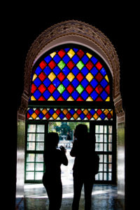 Bahia Palace Marrakesch, zwei Menschen / Silhouetten von Menschen unter buntem Fensterglas Bahia Palace Marrakesch, zwei Menschen / Silhouetten von Menschen unter buntem Fensterglas