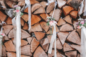 Detail, wedding, pile of wood, logs decorated with small bouquets of flowers Detail, wedding, pile of wood, logs decorated with small bouquets of flowers