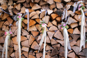 Detail, wedding, pile of wood, logs decorated with small bouquets of flowers Detail, wedding, pile of wood, logs decorated with small bouquets of flowers