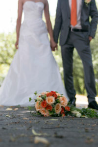 Detail shot, wedding, bridal couple, bouquet of flowers in focus Detail shot, wedding, bridal couple, bouquet of flowers in focus
