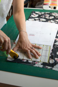 Detail view of fabrics at a sewing workshop Woman cutting fabric Detail view of fabrics at a sewing workshop Woman cutting fabric