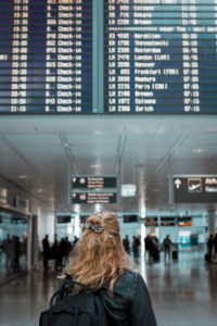 Junge blonde Frau am Flughafen München mit Mund-Nasen-Maske / Corona-Reise / Fluggast mit Schutzmaske Junge blonde Frau am Flughafen München mit Mund-Nasen-Maske / Corona-Reise / Fluggast mit Schutzmaske