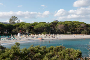 Beach section in Sardinia, private beach of a hotel complex with deck chairs and tourists Beach section in Sardinia, private beach of a hotel complex with deck chairs and tourists