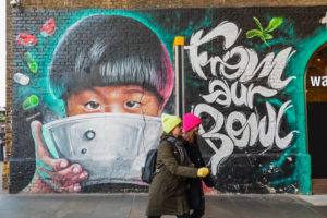 England, London, Southwark, Clink Street, Two Girls Walking Past Wall Mural Street Art depicting Asian Child Eating from Bowl England, London, Southwark, Clink Street, Two Girls Walking Past Wall Mural Street Art depicting Asian Child Eating from Bowl