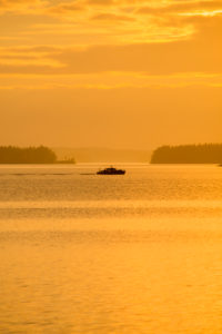 Boat silhouette against the horizon, sunset colors, Finland Boat silhouette against the horizon, sunset colors, Finland