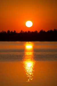 Sunset is reflecting on the lake surface, August, Finland Sunset is reflecting on the lake surface, August, Finland