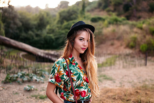 Portrait of girl wearing bikini top leaning against tree