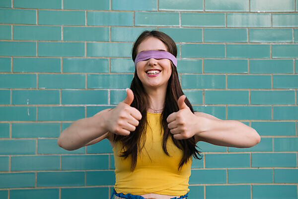 Blindfolded woman holding hands out in front of herself