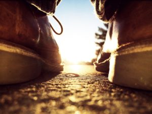 low angle backlit shot of a leather shoe on a street